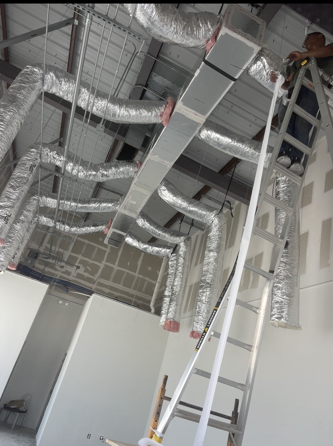 Technician installing commercial flexible ductwork